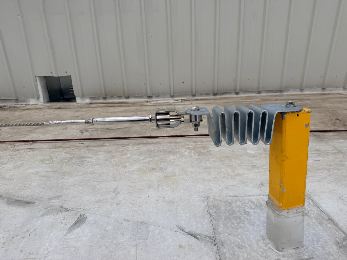 Poste intermedio con absorbedor de energía y tensor montado sobre cubierta de hormigón
