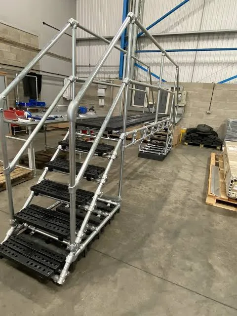 Plataforma de cruce con escalones y barandilla armada en taller